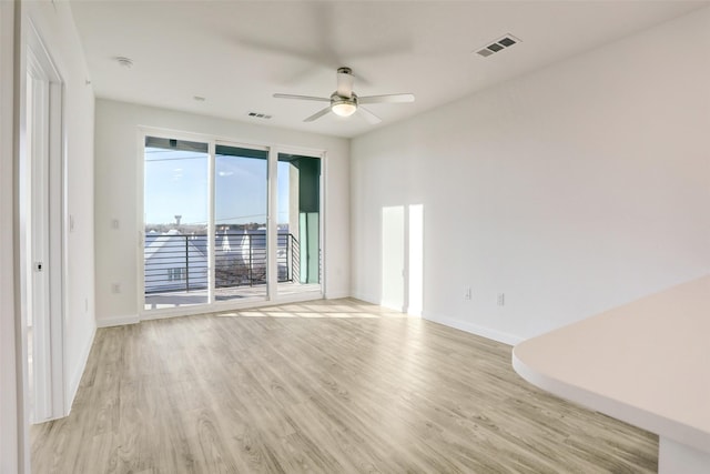 spare room with ceiling fan and light wood-type flooring