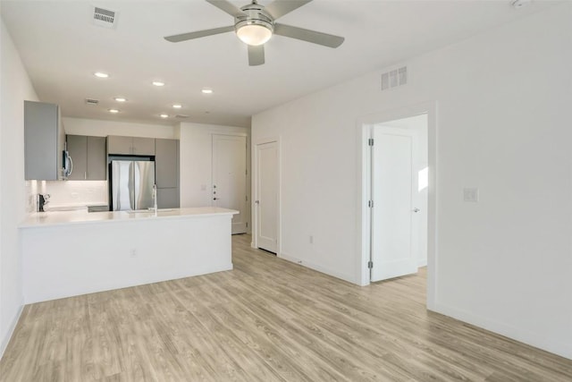 4801 Springdale Rd Unit 2311, Austin, TX 78723 - unfurnished living room with recessed lighting, light wood-style floors, a ceiling fan, baseboards, and a sink