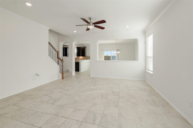 unfurnished living room with ceiling fan, ornamental molding, and light tile patterned flooring