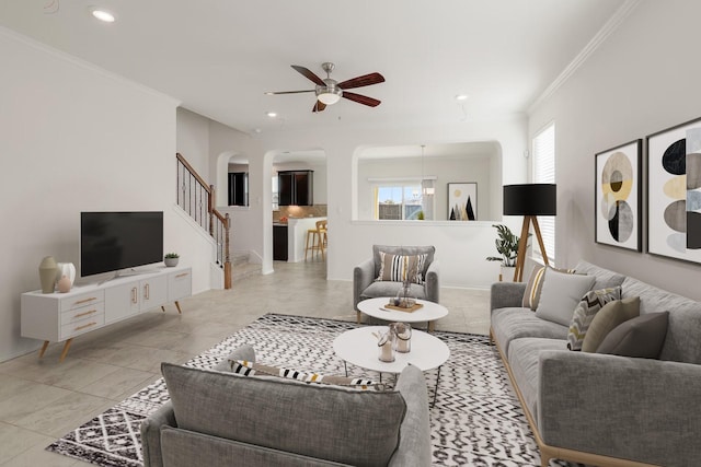 living room featuring light tile patterned floors, ceiling fan, and crown molding