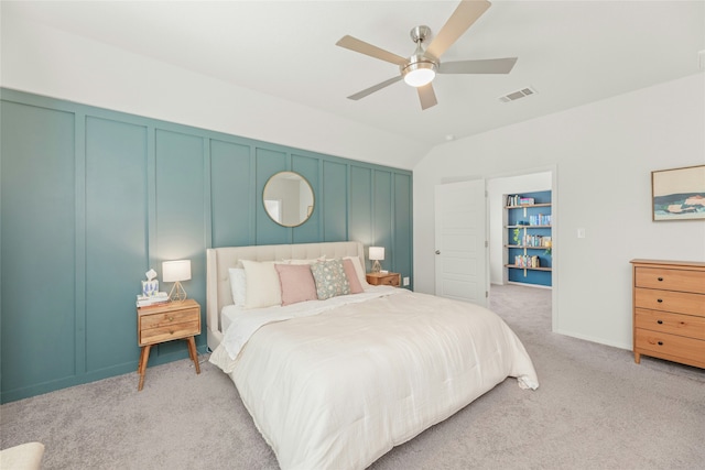 bedroom with ceiling fan, light colored carpet, and vaulted ceiling