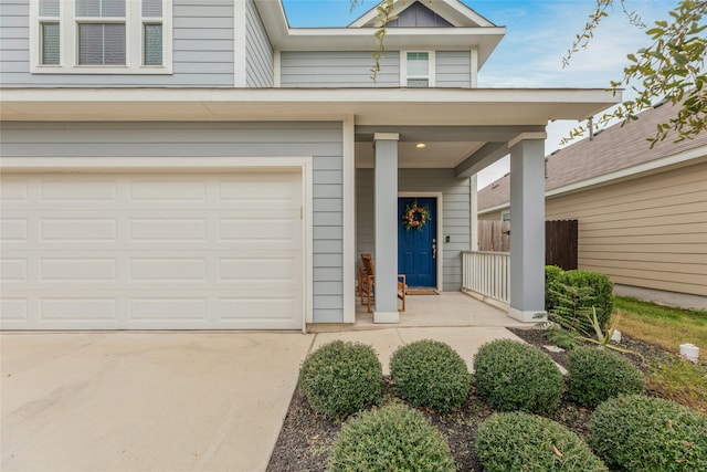 view of exterior entry featuring covered porch and a garage