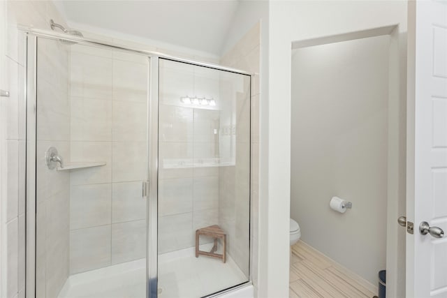 bathroom featuring toilet and a shower with door