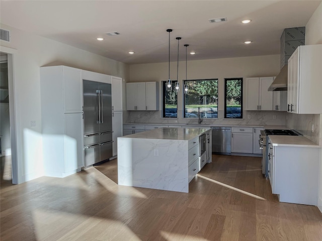 kitchen featuring sink, a center island, backsplash, high quality appliances, and pendant lighting