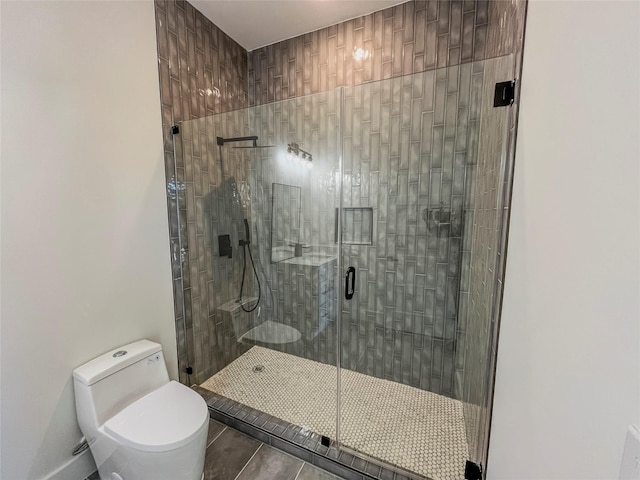 bathroom featuring toilet, tile patterned flooring, and a shower with door