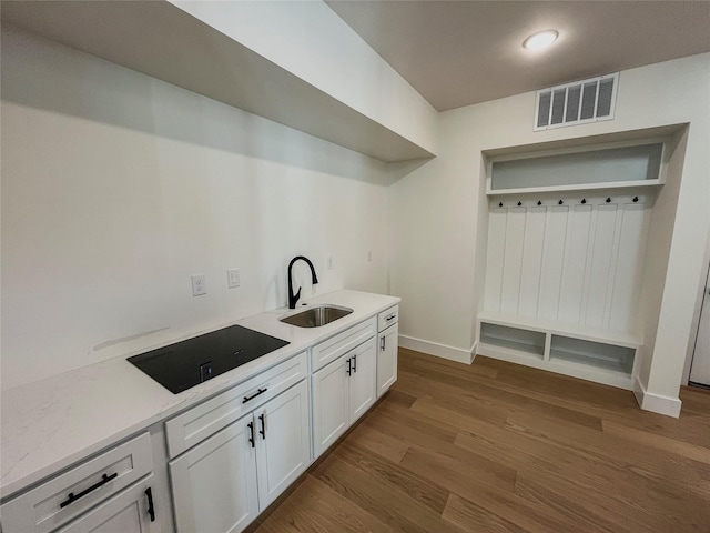 kitchen featuring sink, white cabinetry, hardwood / wood-style floors, and black electric cooktop