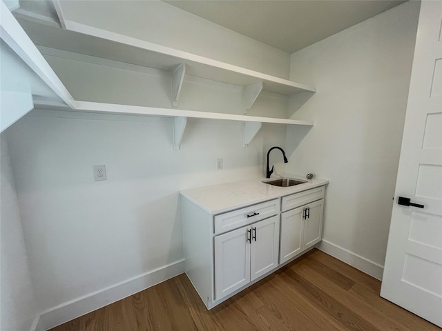 laundry area featuring hardwood / wood-style floors and sink