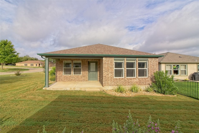 rear view of property featuring a lawn and a patio area