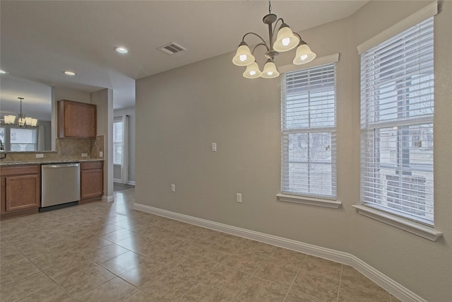 kitchen featuring a notable chandelier, dishwasher, decorative backsplash, and hanging light fixtures