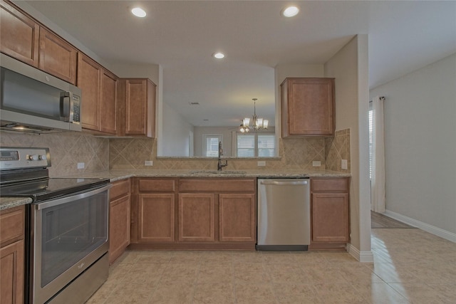 kitchen with sink, an inviting chandelier, backsplash, and appliances with stainless steel finishes