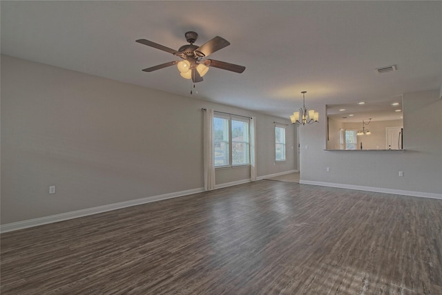 unfurnished living room with ceiling fan with notable chandelier and dark hardwood / wood-style flooring