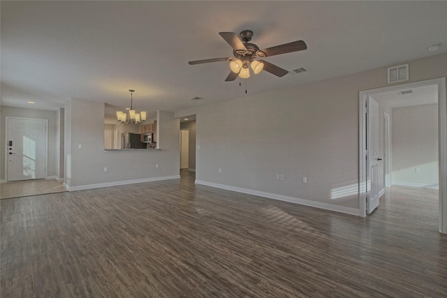 unfurnished living room featuring ceiling fan with notable chandelier and dark wood-type flooring