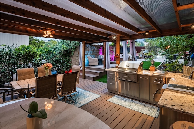 wooden terrace with an outdoor kitchen and area for grilling