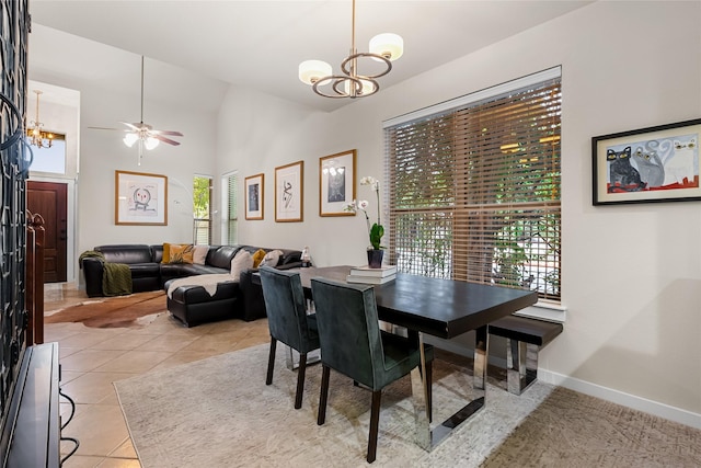 tiled dining room with ceiling fan with notable chandelier