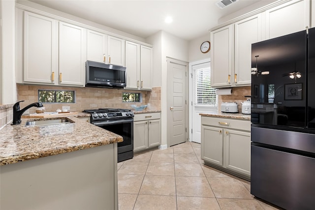 kitchen featuring sink, stainless steel appliances, white cabinetry, and light tile patterned flooring