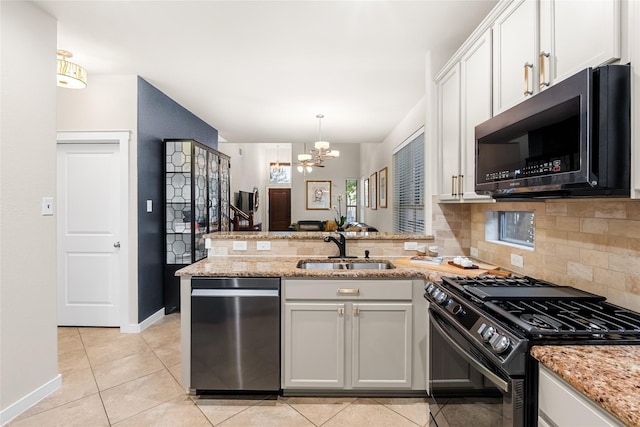 kitchen with appliances with stainless steel finishes, a notable chandelier, decorative backsplash, white cabinets, and sink