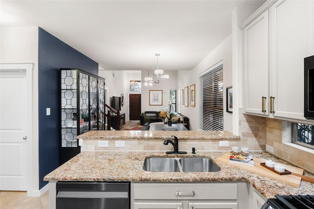 kitchen featuring white cabinets, pendant lighting, light stone counters, and a chandelier