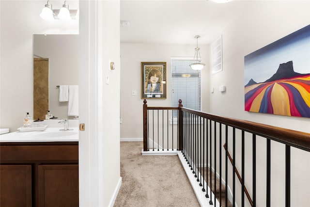 corridor featuring light carpet and sink