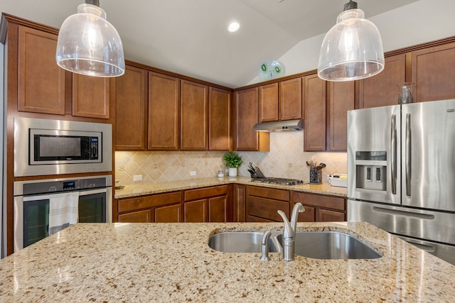 kitchen featuring stainless steel appliances, sink, light stone counters, lofted ceiling, and hanging light fixtures