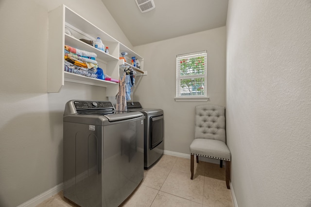 clothes washing area featuring washing machine and dryer and light tile patterned flooring