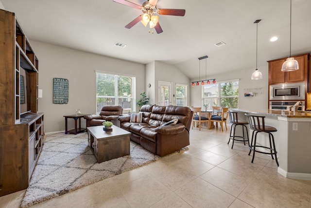 tiled living room featuring ceiling fan and vaulted ceiling