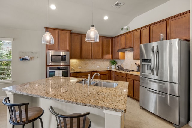 kitchen with vaulted ceiling, hanging light fixtures, backsplash, appliances with stainless steel finishes, and sink