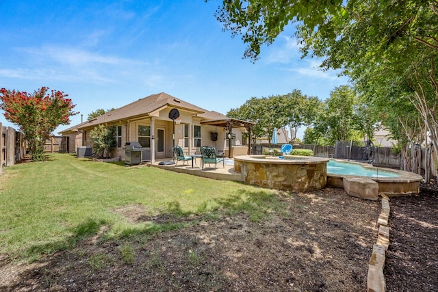 back of house with central AC, a yard, a fenced in pool, and a patio area