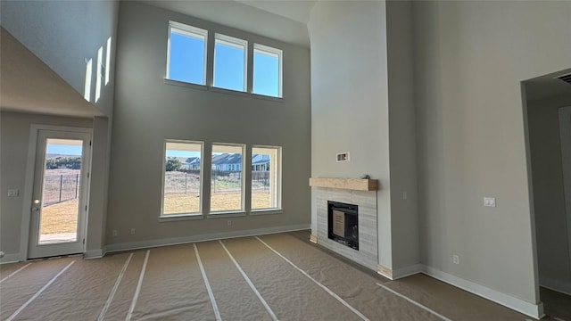 unfurnished living room featuring carpet and a high ceiling