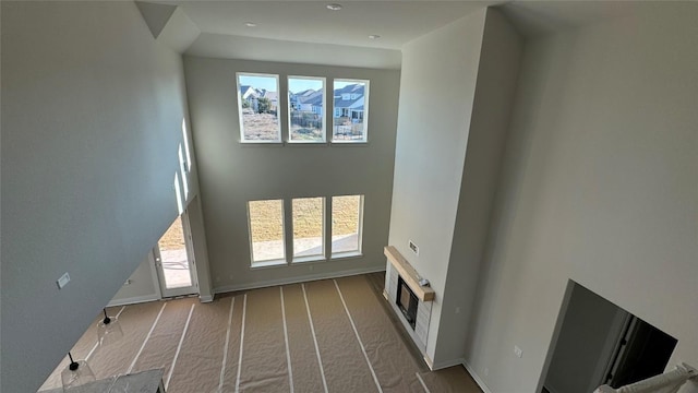 unfurnished living room featuring a towering ceiling and light carpet