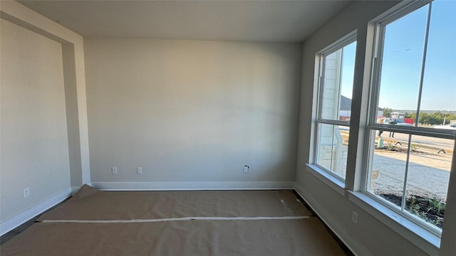 unfurnished room featuring dark colored carpet