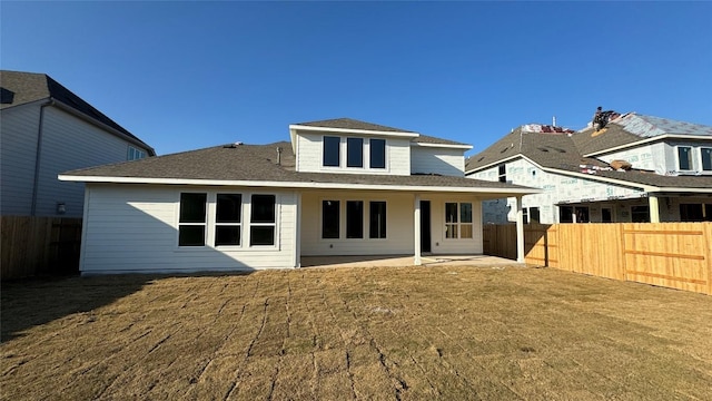 back of house with a lawn and a patio