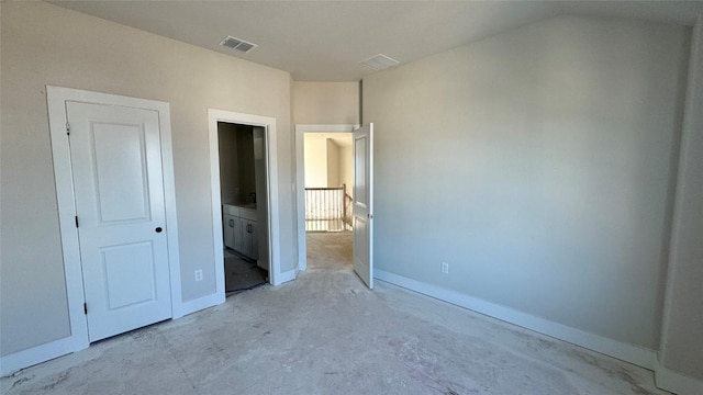 unfurnished bedroom with connected bathroom and vaulted ceiling