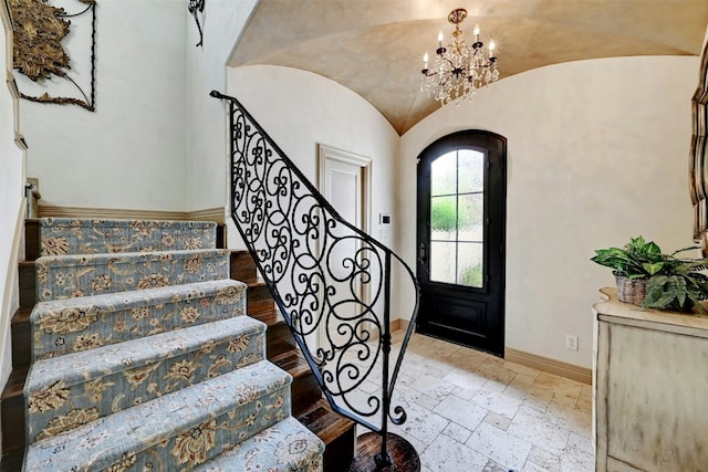 foyer with vaulted ceiling and a chandelier