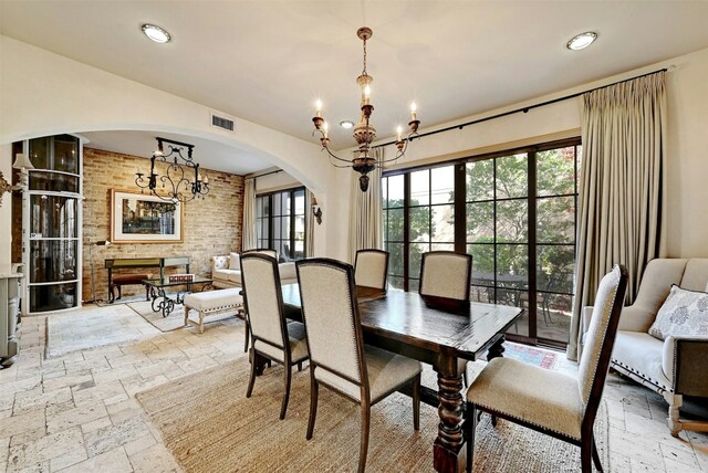 dining area featuring a chandelier and a fireplace