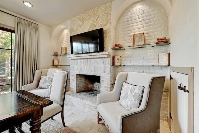 sitting room with a brick fireplace