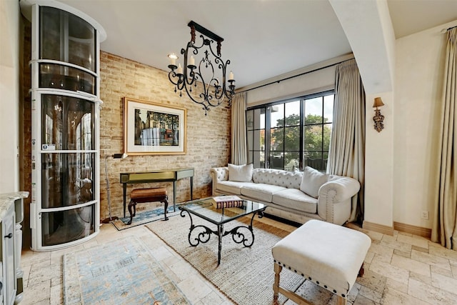 living room featuring a chandelier and brick wall