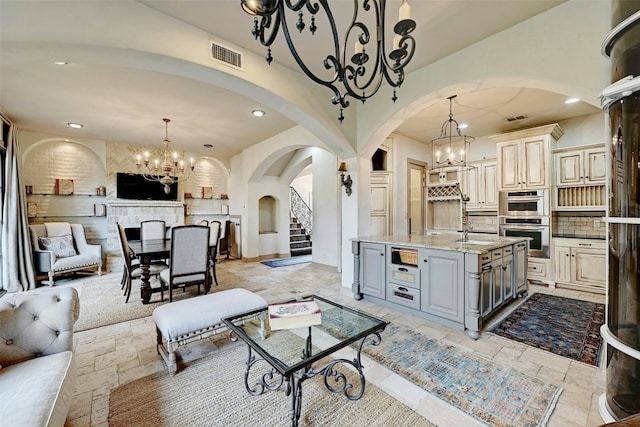 2433 Westlake Dr, Austin, TX 78746 - living room with a chandelier, arched walkways, stone tile flooring, and recessed lighting