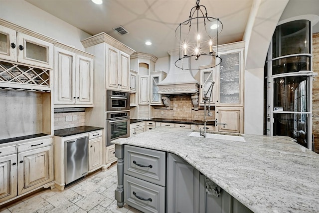 kitchen featuring pendant lighting, dark stone counters, premium range hood, and gray cabinetry