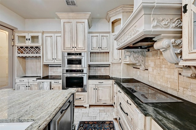 2433 Westlake Dr, Austin, TX 78746 - kitchen with black electric stovetop, double oven, tasteful backsplash, premium range hood, and glass insert cabinets