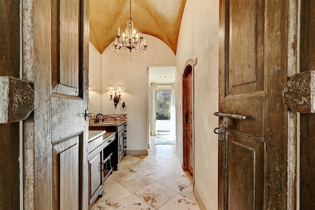 2433 Westlake Dr, Austin, TX 78746 - interior space featuring a chandelier, lofted ceiling, a sink, decorative light fixtures, and baseboards