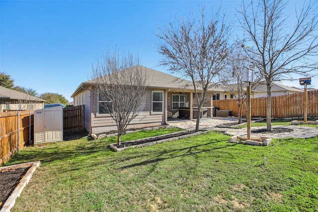 back of house featuring a patio area, a storage unit, and a yard