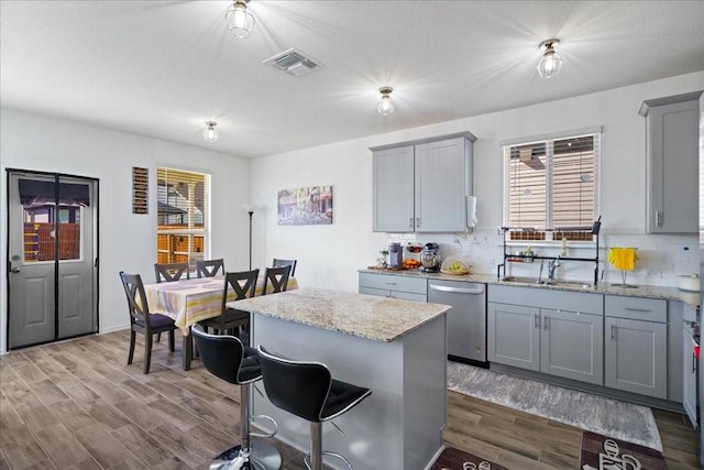 kitchen featuring a kitchen island, decorative backsplash, dishwasher, and gray cabinets