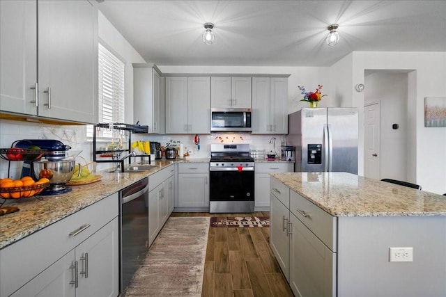 kitchen featuring appliances with stainless steel finishes, dark hardwood / wood-style floors, decorative backsplash, and sink