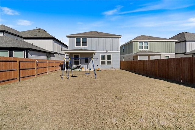 rear view of house featuring a playground