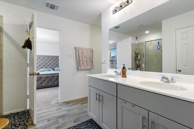 bathroom with a shower with shower door and vanity