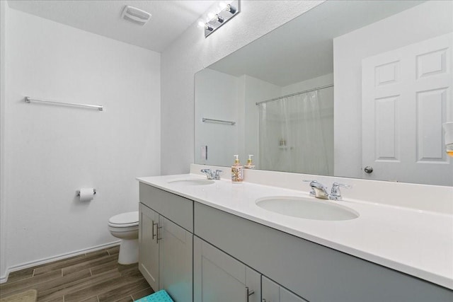 bathroom with toilet, a shower with shower curtain, and vanity