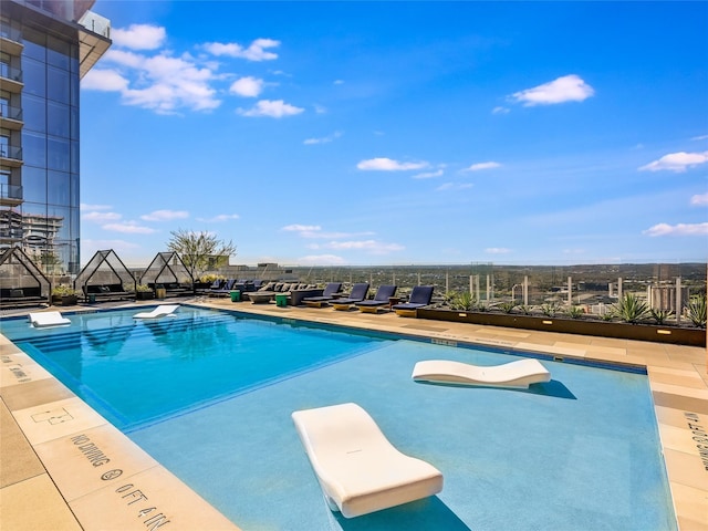 view of swimming pool featuring a diving board and a patio