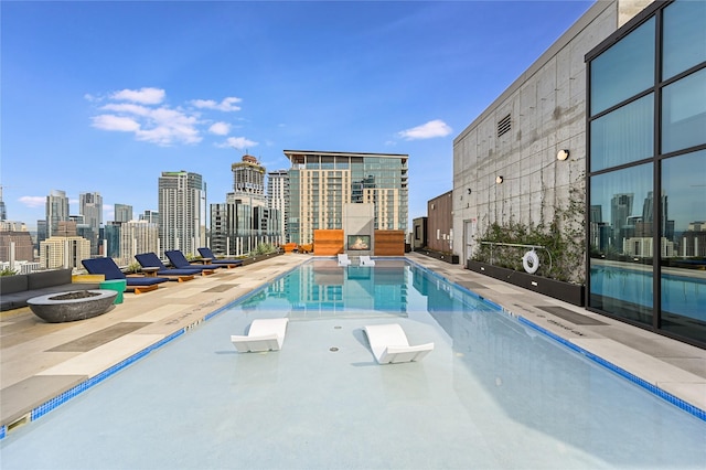 view of swimming pool with a patio area and a fire pit