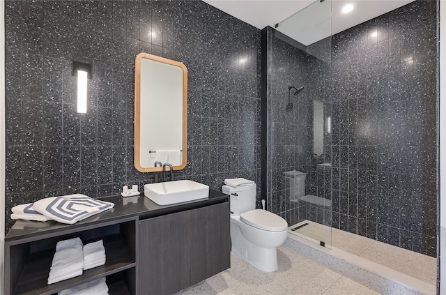 bathroom with a shower, tile walls, toilet, and vanity