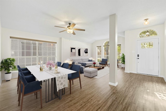 dining area with ceiling fan, vaulted ceiling, and hardwood / wood-style flooring